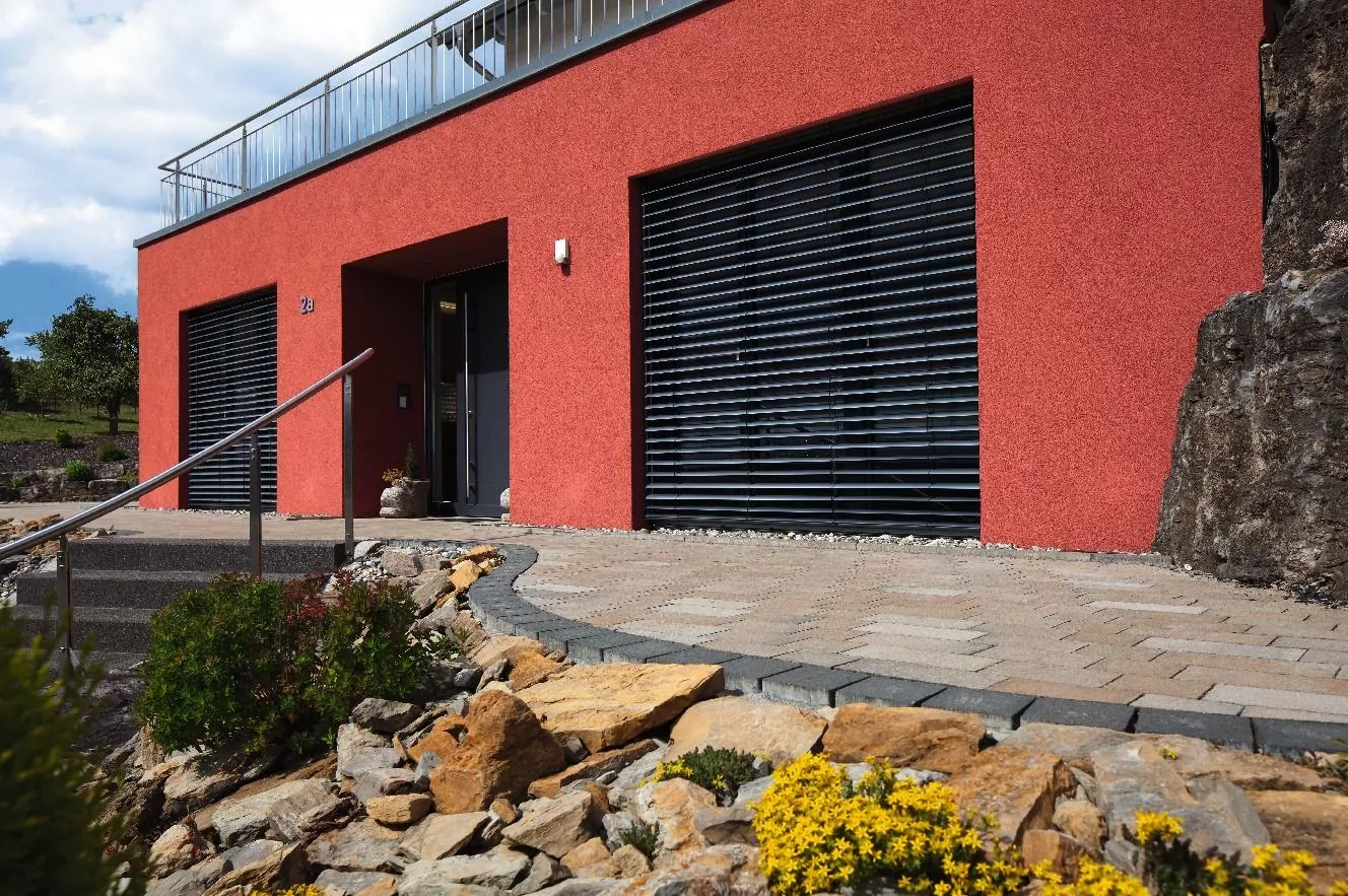 Effiziente Rollläden von Warema für optimalen Sonnenschutz Aufstaz Rollladen an rotem Haus