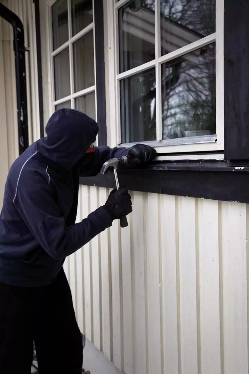Ein Mann versucht durch ein Fenster einzubrechen