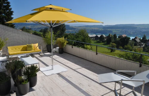 Moderne Terrasse mit gelbem Sonnenschirm und Panoramablick