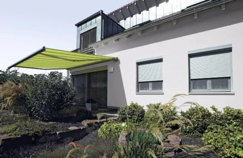 Moderne Markise an einem Einfamilienhaus mit gepflegtem Garten