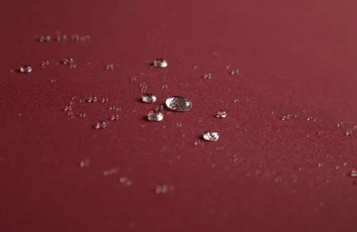 Wassertropfen auf rotem Stoff