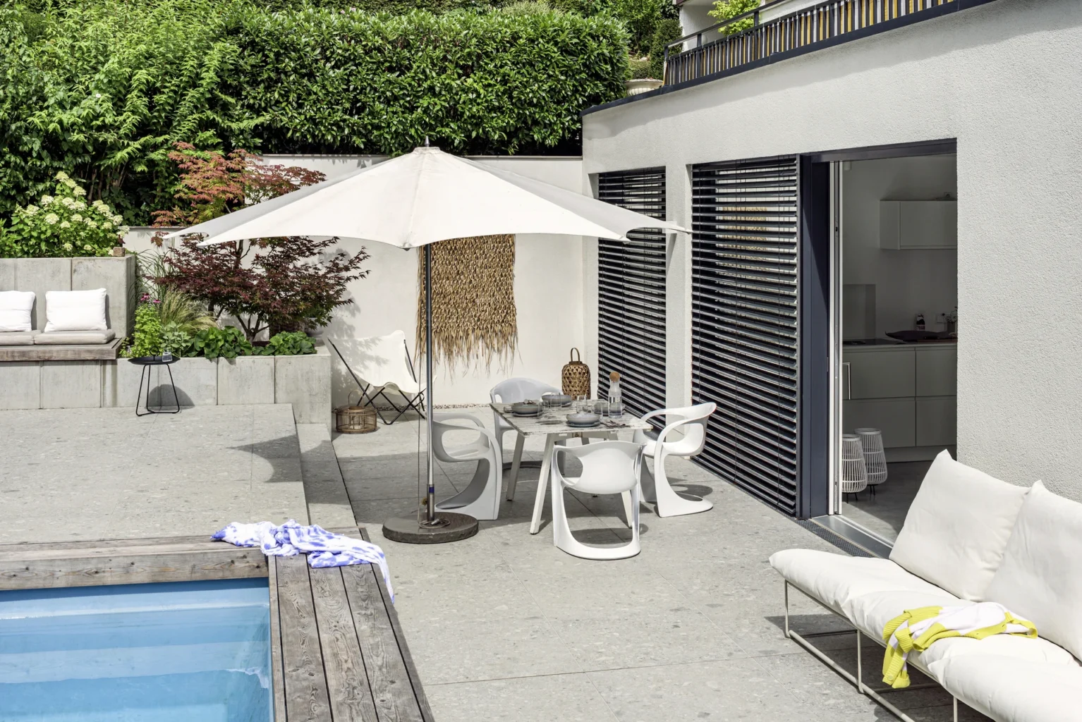 Moderne Terrasse mit Pool und stilvollen Gartenmöbeln