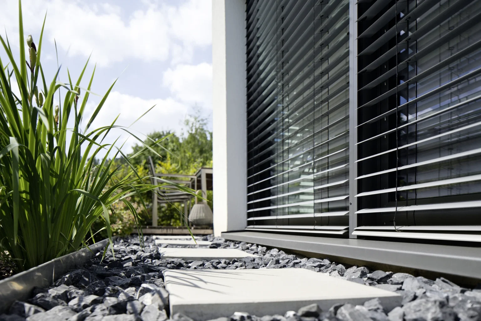 Moderne Jalousien an einem Haus mit Garten