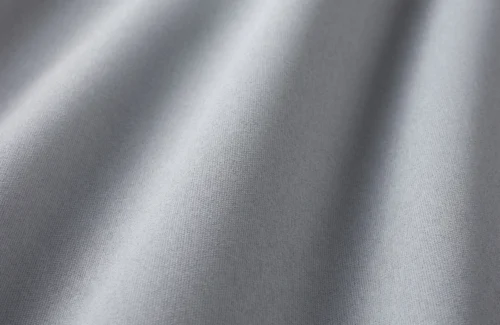 Grauer Stoff in Nahaufnahme mit weichen Falten